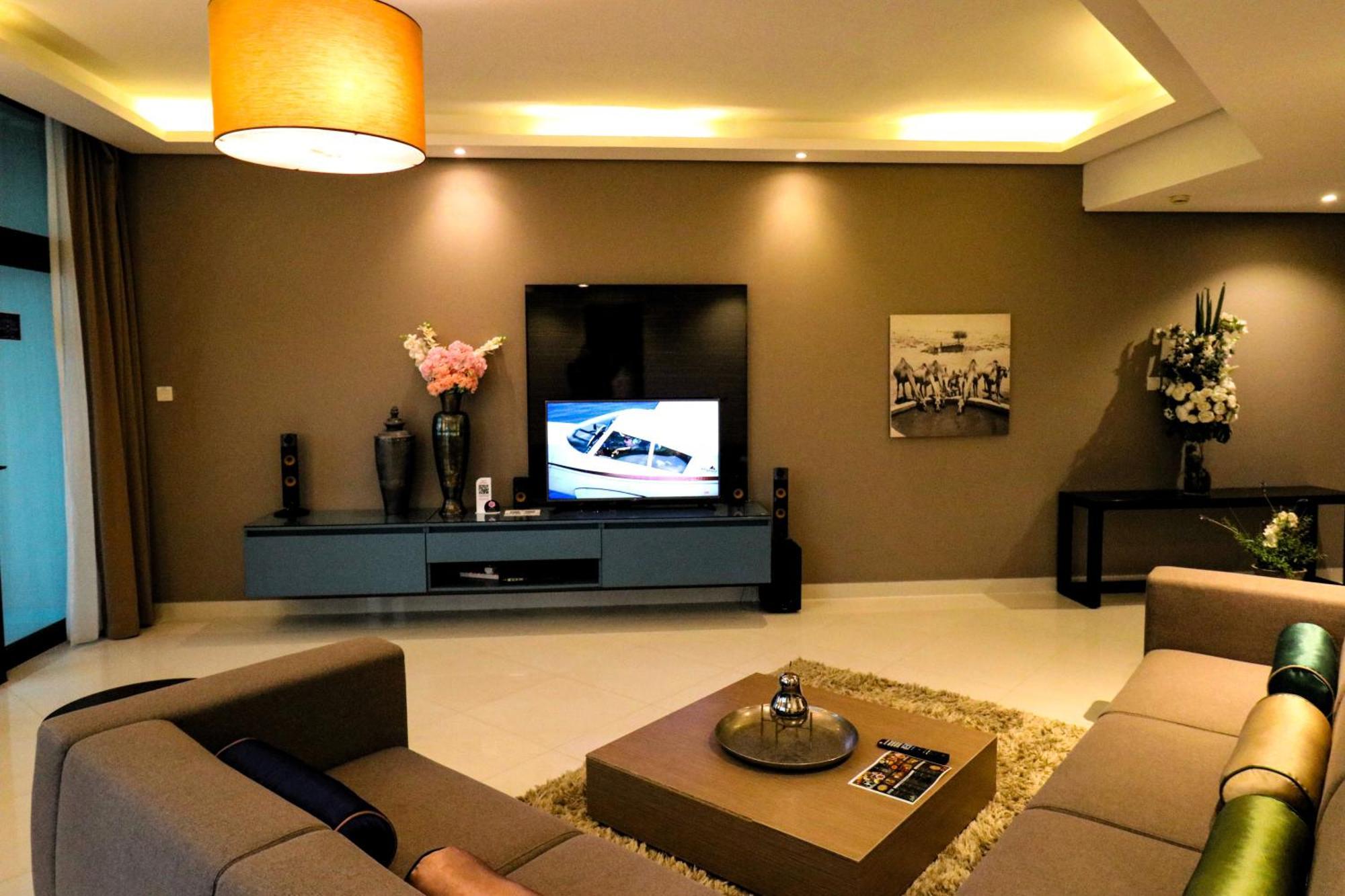 泻湖畔豪华spa度假村 麦纳麦 外观 照片 The photo shows a modern living room with a neutral color palette. Key features include:

- A comfortable seating area with a sofa arranged around a coffee table.
- A minimalist coffee table with a decorative item on top.
- A large flat-screen televi