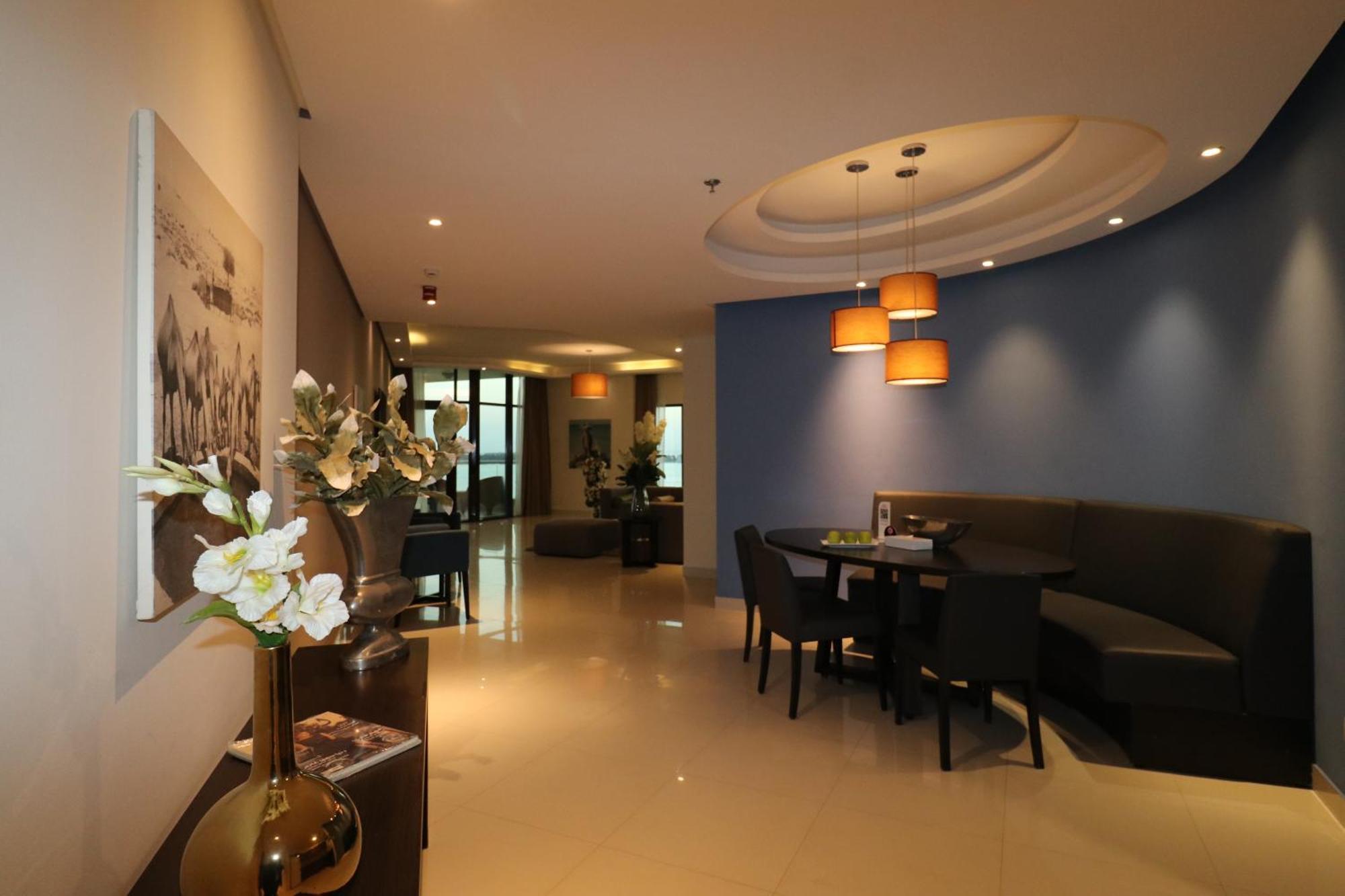 泻湖畔豪华spa度假村 麦纳麦 外观 照片 The photo showcases an interior space, likely a modern lounge or reception area. It features a combination of soft lighting, neutral-colored walls, and decorative elements. There are elegant light fixtures hanging from the ceiling, and a curved blue 